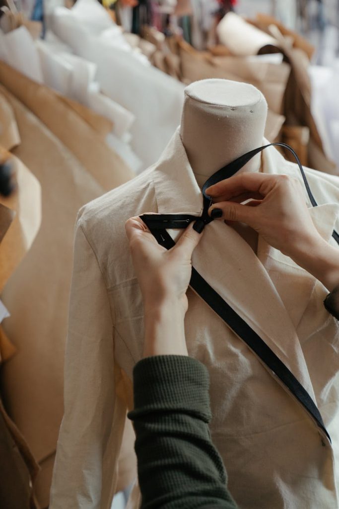 person in white dress shirt and black necktie holding white suit jacket